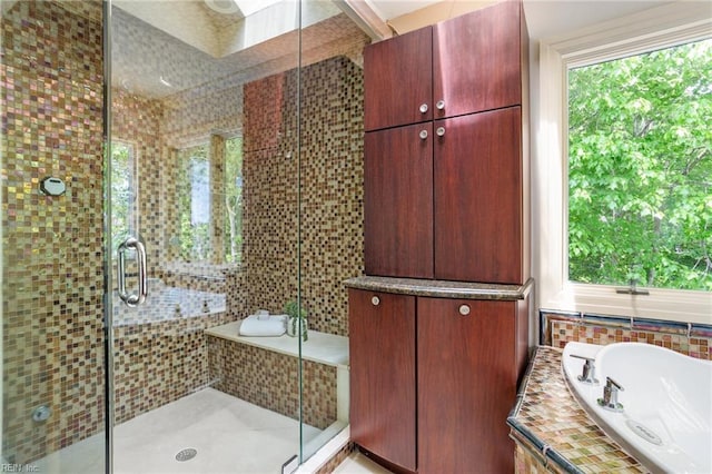 bathroom featuring plenty of natural light, a bath, and a stall shower
