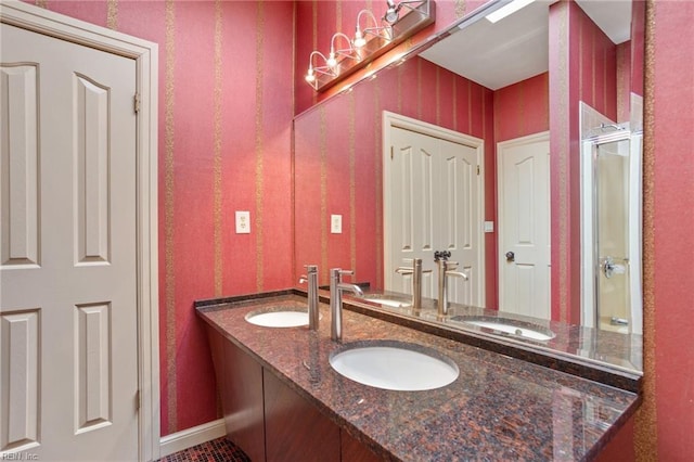 full bathroom featuring a sink, an enclosed shower, and double vanity