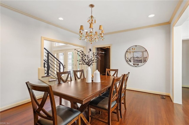 dining room with an inviting chandelier, baseboards, crown molding, and wood finished floors