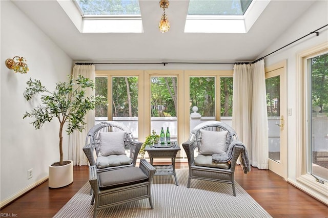 sunroom with wood finished floors and lofted ceiling with skylight