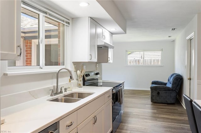kitchen with a sink, dark wood-style flooring, white cabinets, and stainless steel range with electric cooktop