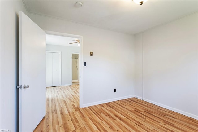 spare room featuring baseboards and light wood finished floors