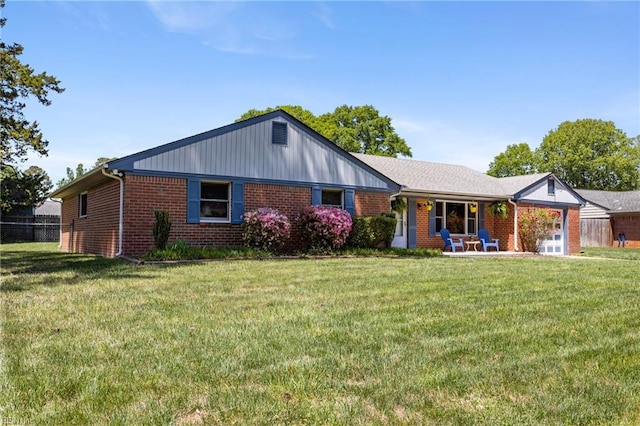 single story home featuring brick siding, fence, and a front yard