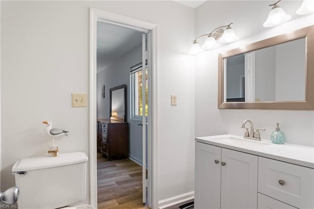 bathroom featuring vanity, baseboards, toilet, and wood finished floors