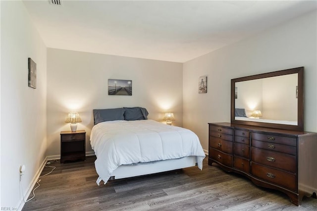 bedroom with baseboards and wood finished floors