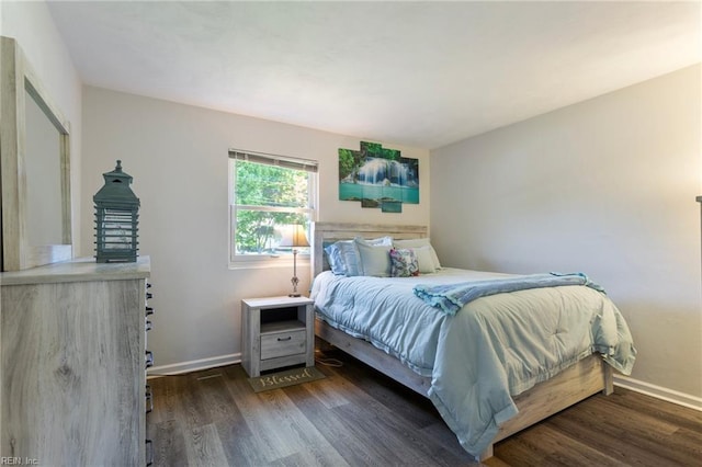 bedroom with baseboards and wood finished floors