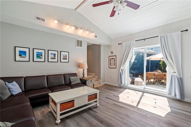 living area featuring lofted ceiling with beams, visible vents, and wood finished floors