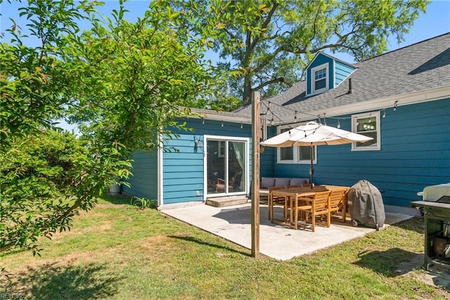 back of house featuring a yard, roof with shingles, and a patio area