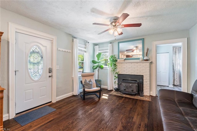 entrance foyer with wood finished floors, a fireplace, a textured ceiling, baseboards, and ceiling fan
