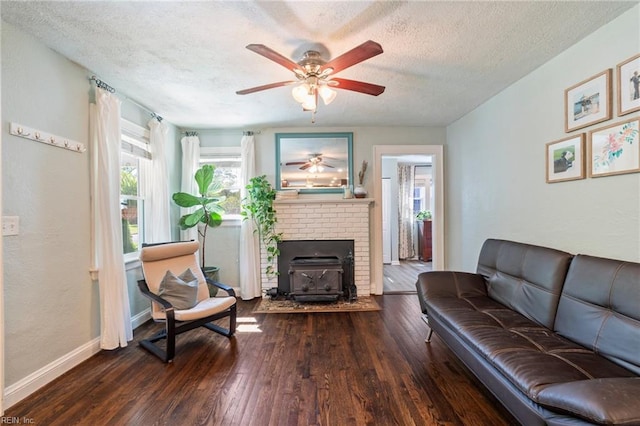 living area featuring ceiling fan, a textured ceiling, baseboards, and hardwood / wood-style floors