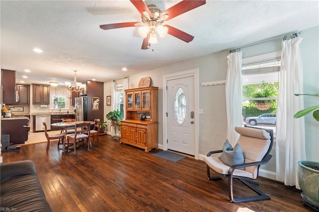 foyer entrance with recessed lighting, a textured ceiling, ceiling fan with notable chandelier, and dark wood-style floors