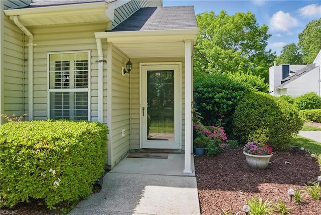 property entrance featuring a shingled roof