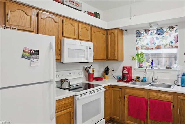 kitchen featuring a sink, brown cabinets, white appliances, and light countertops