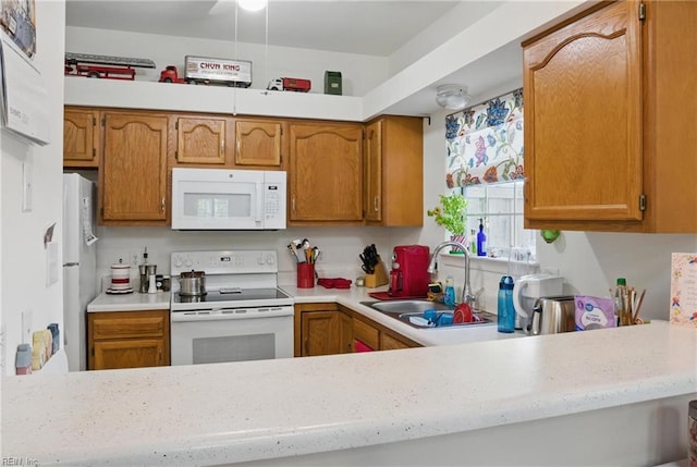 kitchen featuring white appliances, brown cabinetry, a sink, and light countertops
