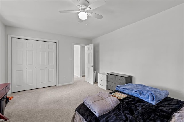 bedroom featuring a ceiling fan, baseboards, light carpet, and a closet
