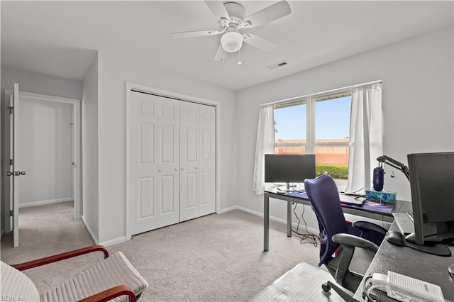 carpeted home office featuring baseboards, a ceiling fan, and visible vents