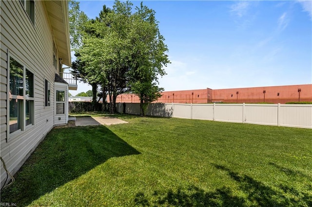 view of yard with a fenced backyard, a patio area, and a balcony