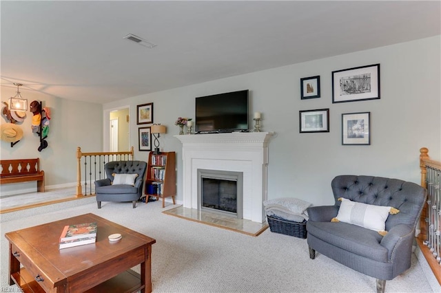 carpeted living area featuring visible vents and a fireplace with raised hearth