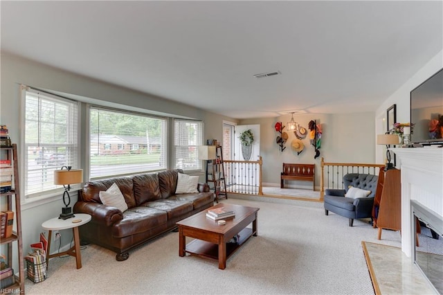 living area with visible vents, carpet flooring, and a fireplace with flush hearth