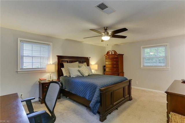 bedroom featuring visible vents, baseboards, ceiling fan, and light carpet