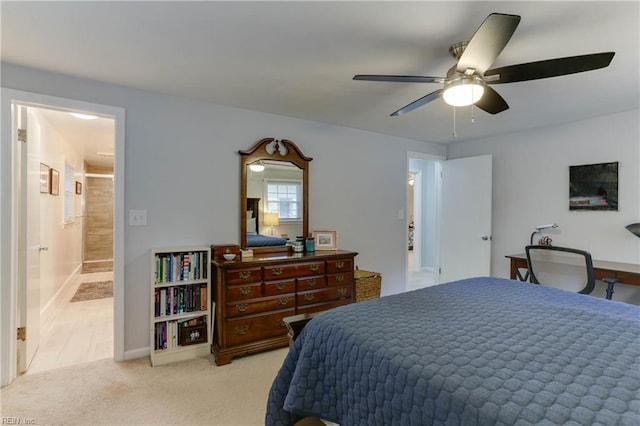 bedroom featuring light colored carpet, a ceiling fan, connected bathroom, and baseboards