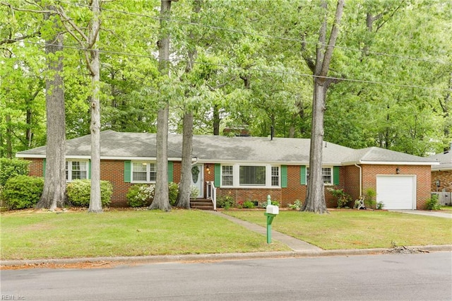 single story home featuring concrete driveway, brick siding, an attached garage, and a front yard