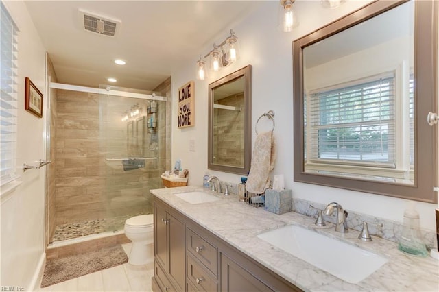 bathroom featuring a sink, a stall shower, toilet, and visible vents