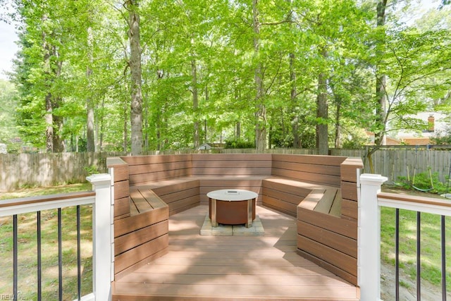 wooden deck with a fenced backyard and an outdoor living space with a fire pit