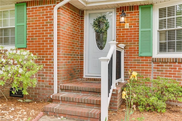 view of exterior entry featuring brick siding