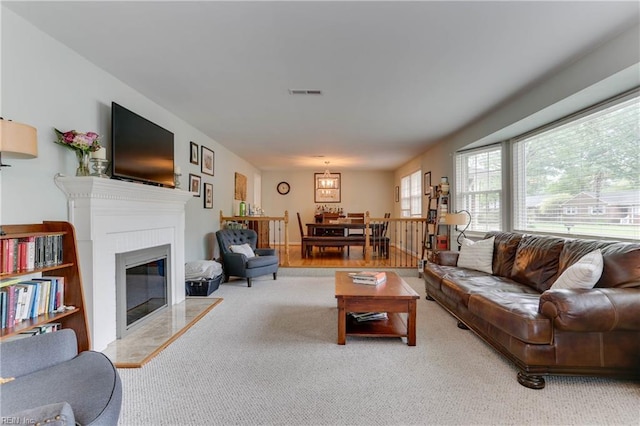 carpeted living area featuring a glass covered fireplace and visible vents