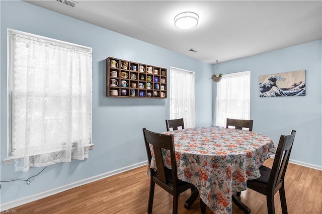 dining area featuring baseboards, visible vents, and wood finished floors