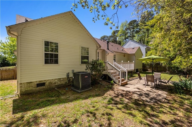 back of property featuring a lawn, central AC, fence, and a patio