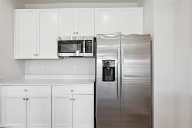 kitchen featuring light countertops, appliances with stainless steel finishes, and white cabinetry