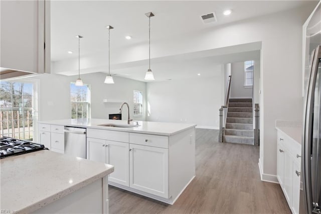 kitchen featuring visible vents, a sink, white cabinetry, and stainless steel appliances
