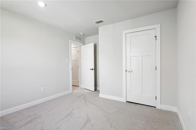 unfurnished bedroom with visible vents, baseboards, and light carpet
