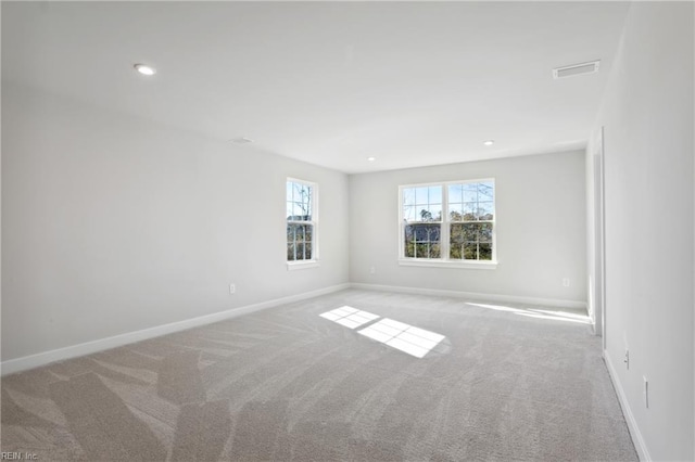 spare room featuring carpet floors, recessed lighting, baseboards, and visible vents