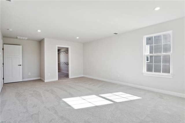 unfurnished bedroom with visible vents, recessed lighting, baseboards, and light carpet