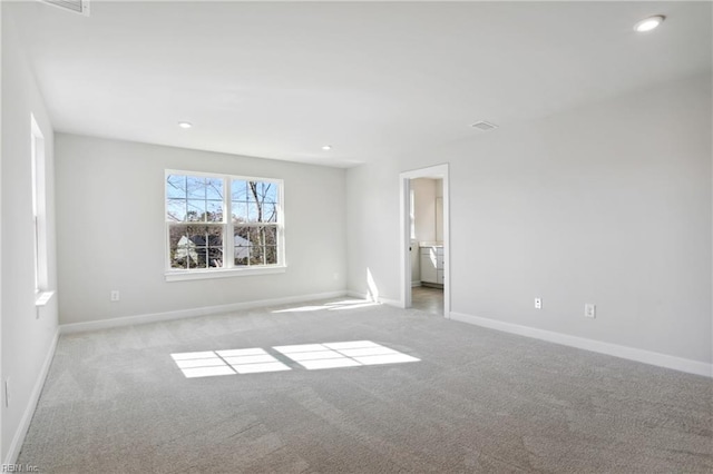 spare room with light colored carpet, recessed lighting, and baseboards