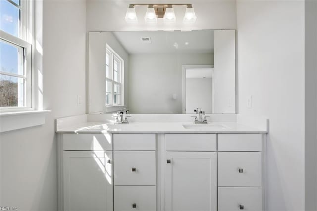 bathroom featuring double vanity, a sink, and visible vents