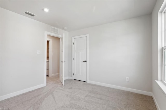 spare room with light colored carpet, baseboards, visible vents, and recessed lighting