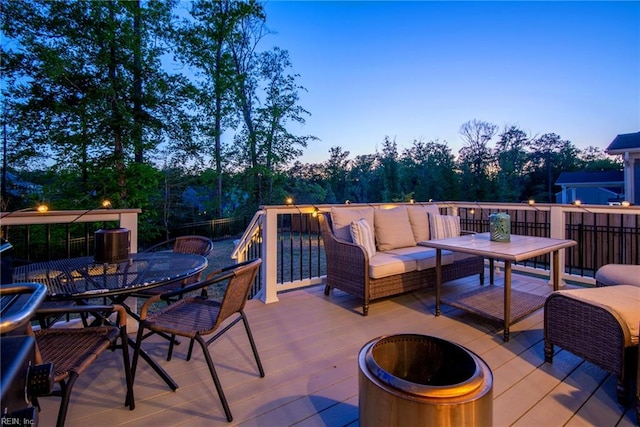 wooden terrace featuring an outdoor living space with a fire pit and outdoor dining space