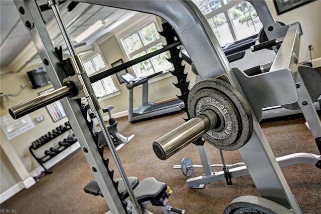 exercise room with baseboards and carpet
