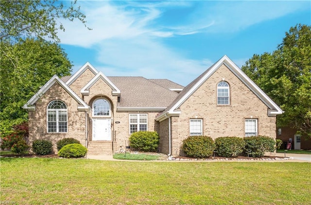 view of front of home featuring a front lawn and brick siding