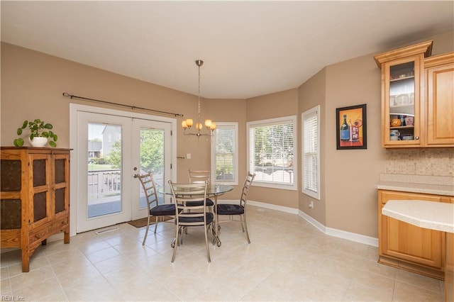 dining room with light tile patterned flooring, baseboards, a notable chandelier, and french doors