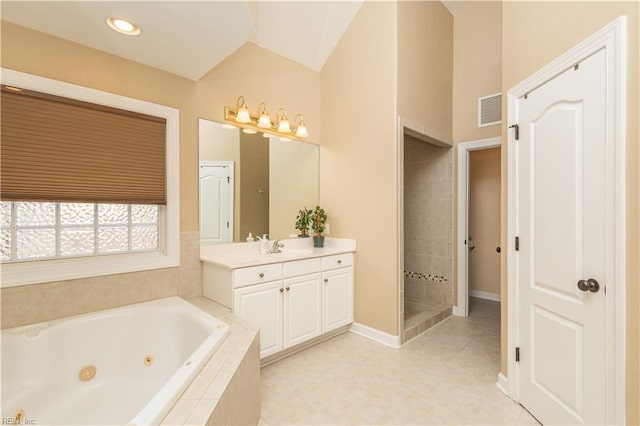 bathroom featuring vanity, a jetted tub, baseboards, vaulted ceiling, and visible vents