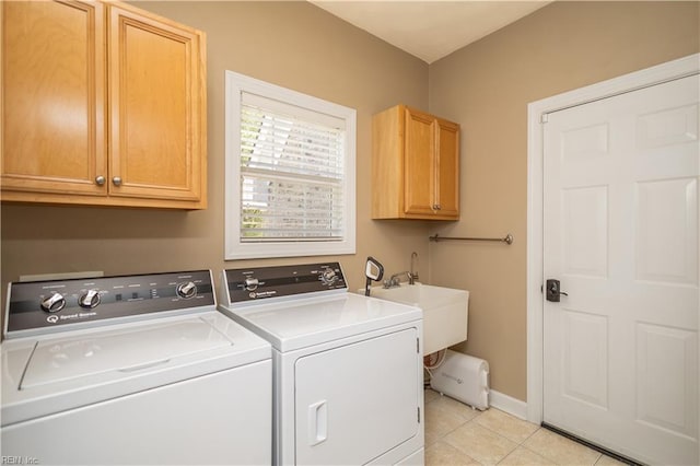 laundry room with cabinet space, a sink, baseboards, light tile patterned flooring, and washer and clothes dryer