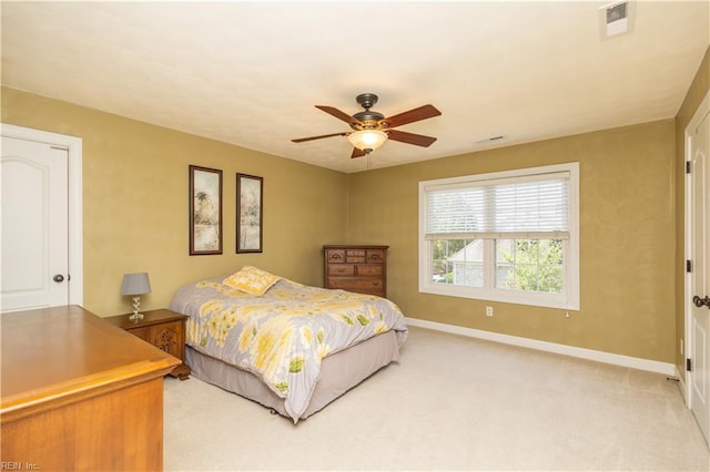 bedroom featuring baseboards, visible vents, a ceiling fan, and light colored carpet