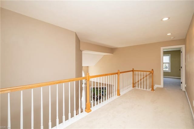 corridor featuring carpet floors, baseboards, recessed lighting, and an upstairs landing