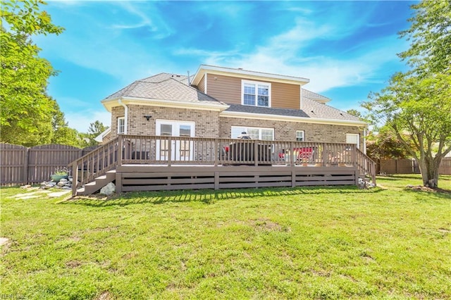 rear view of house with a yard, a deck, brick siding, and a fenced backyard