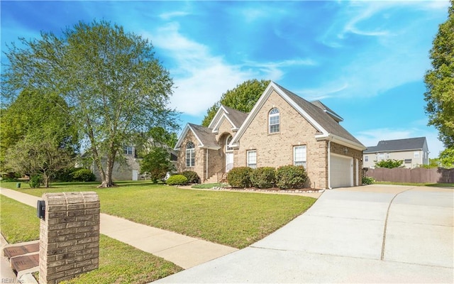 traditional home with fence, driveway, a front lawn, and brick siding